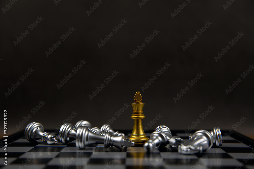 The golden chess king stands in the middle of the falling silver chess. Concepts of leadership and business strategy plans. The golden chess king stands in the middle of the falling silver chess. Concepts of leadership and business strategy plans.