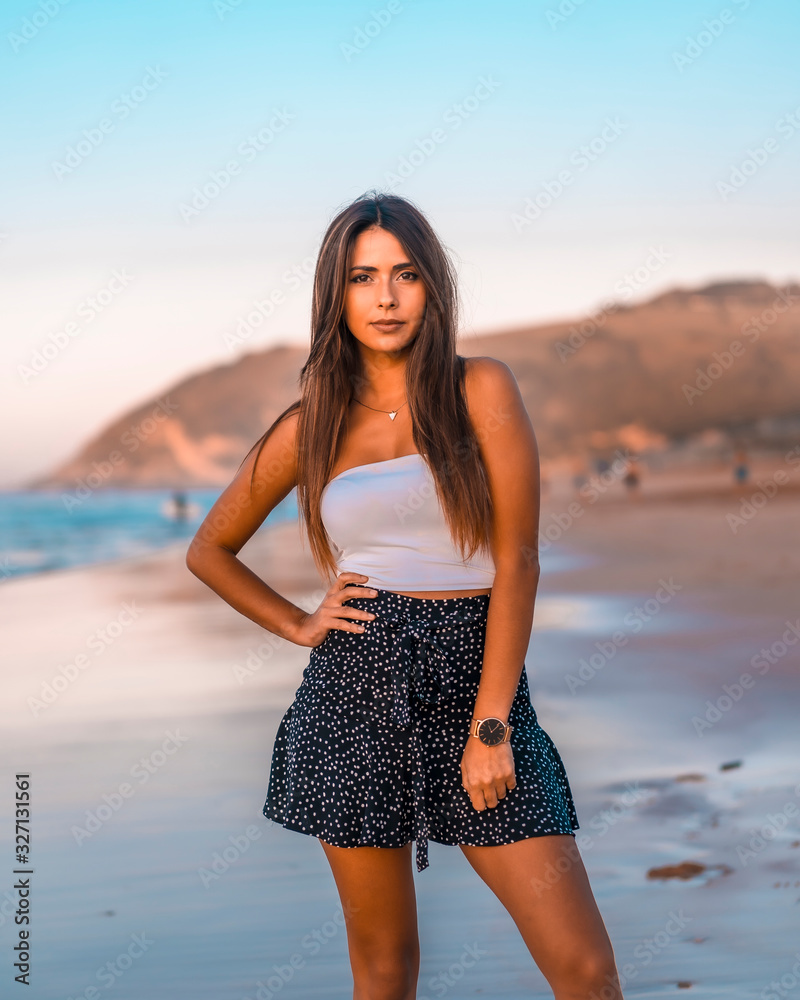 Lifestyle, portrait of a pretty brunette on the beach with a black skirt and a white t-shirt Lifestyle, portrait of a pretty brunette on the beach with a black skirt and a white t-shirt