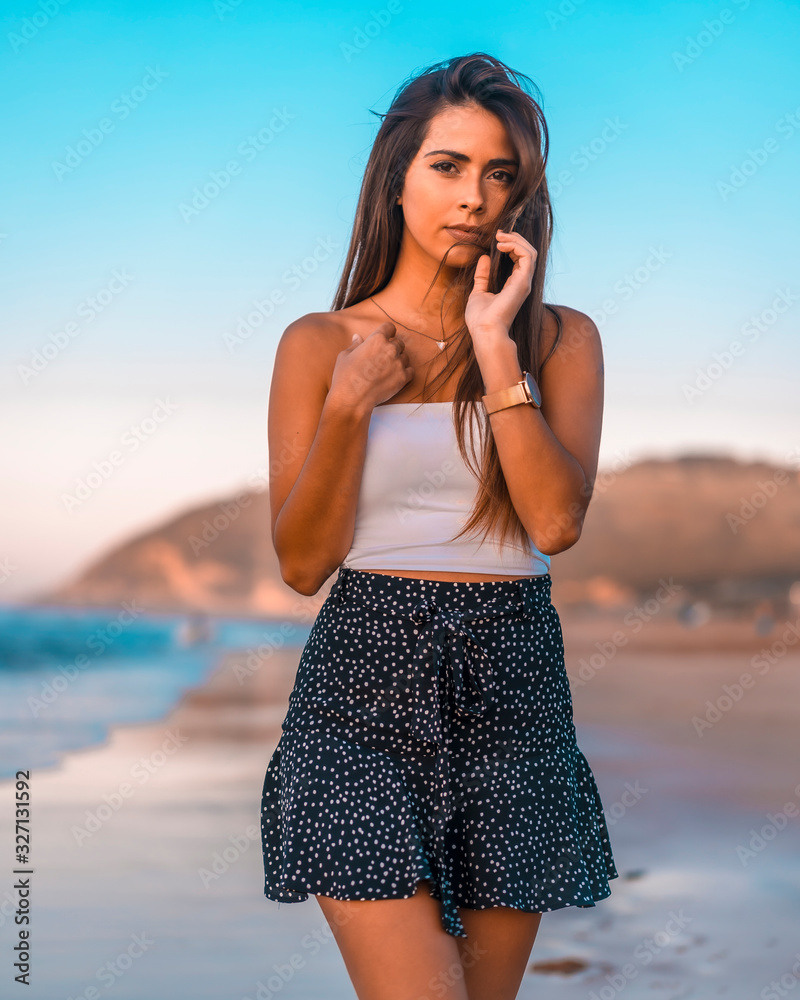 Lifestyle, portrait of a pretty brunette on the beach with a black skirt Lifestyle, portrait of a pretty brunette on the beach with a black skirt