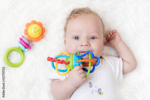 four-month-old boy chewing a rattle