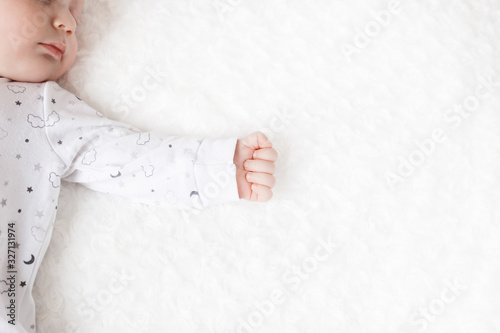 cute baby sleeps in pajamas. baby hand