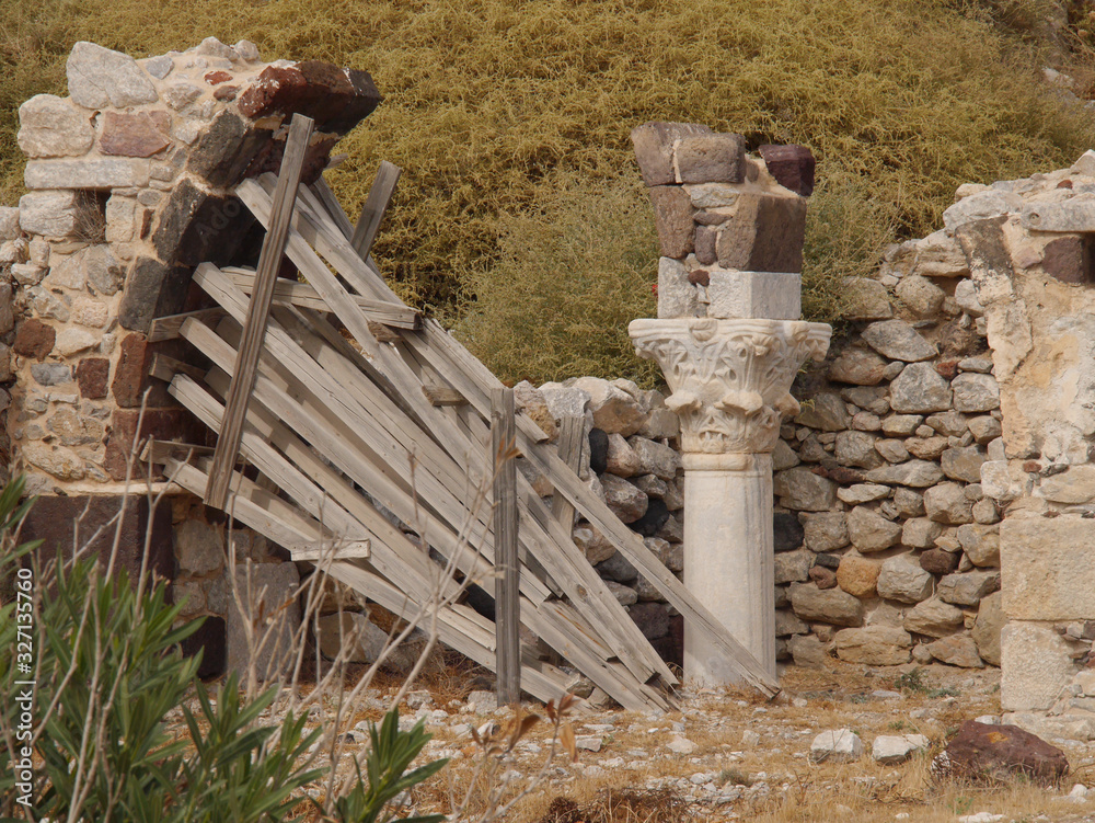 Naklejka premium The ruins of an ancient church, traditional architecture, columns in the historical center of the city of Perissa Santorini island.