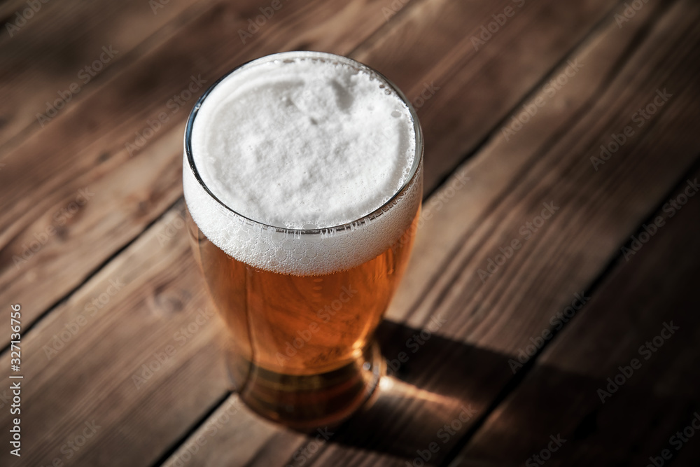 Glass of cold beer on the wooden table of a pub - obrazy, fototapety, plakaty 