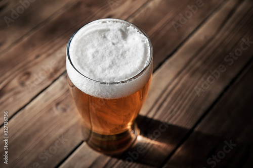 Canvas Print Glass of cold beer on the wooden table of a pub