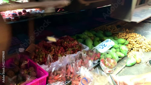 Closeup of grocery goods on the ground under the train driving over in maeklong railway market
