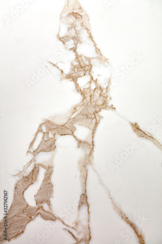 The surface, texture and background of white beige marble with brown veins.