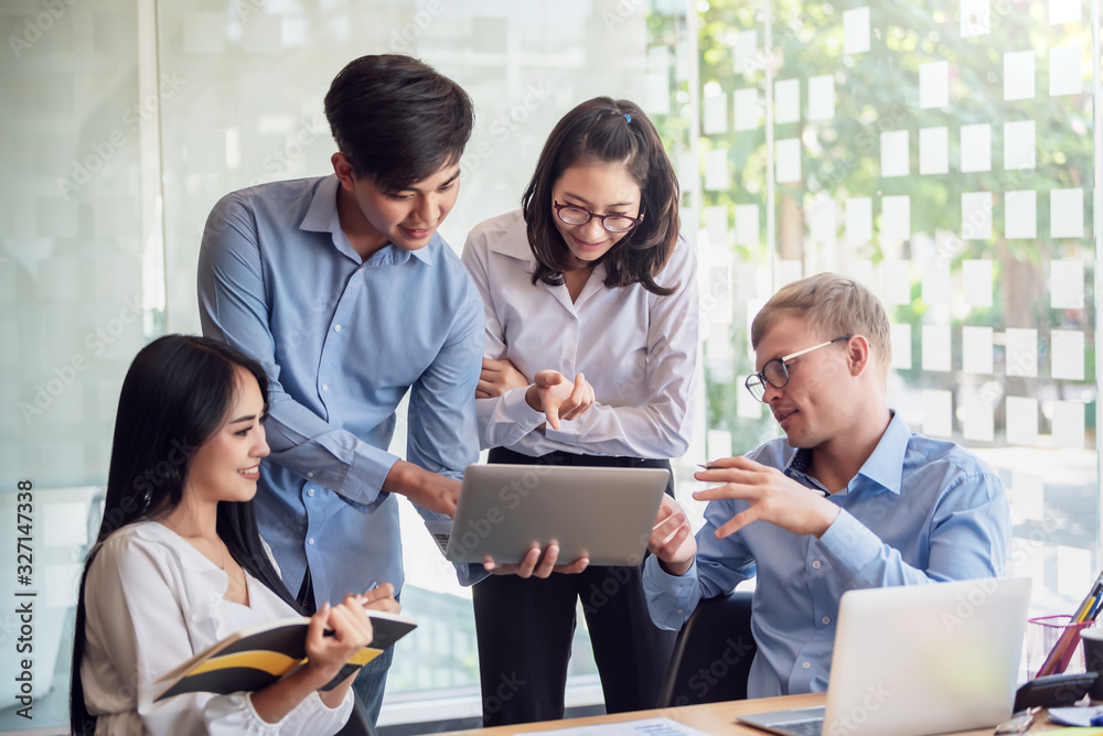 Group of young asian modern people in smart casual wear talking and smiling during the meeting in office. Group of young asian modern people in smart casual wear talking and smiling during the meeting in office.
