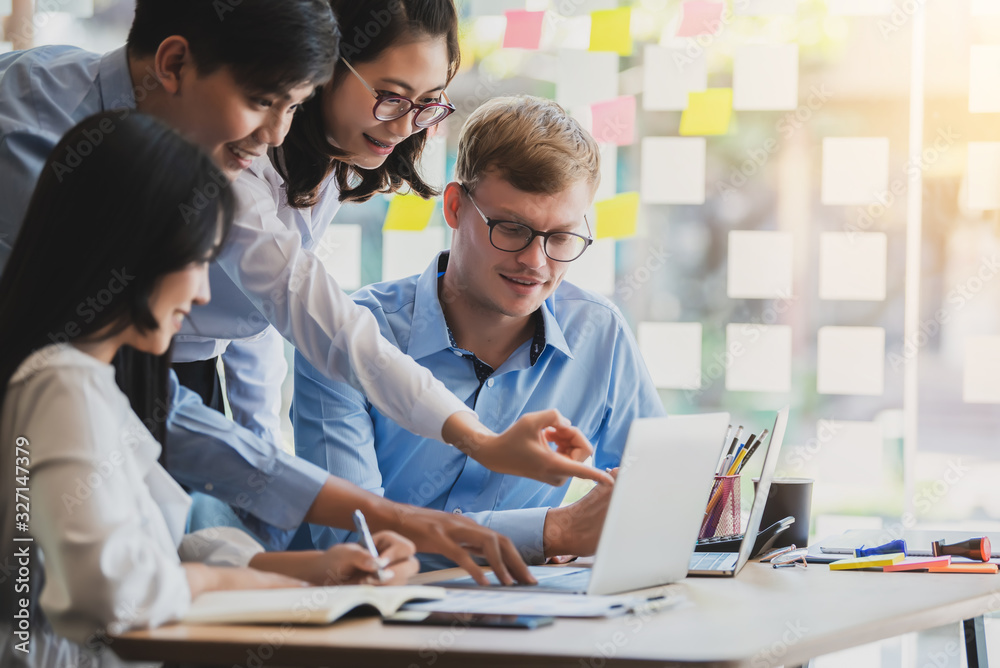 Group of young asian modern people in smart casual wear talking and smiling during the meeting in office. Group of young asian modern people in smart casual wear talking and smiling during the meeting in office.