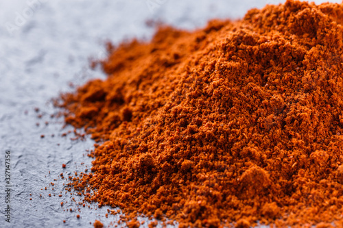 aromatic spicy chilli powder on a dark stone background