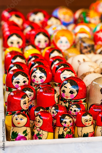 Lots of traditional national russian red matryoshka toy dolls, market stall closeup, selective focus. Slavic eastern culture symbols abstract concept photo