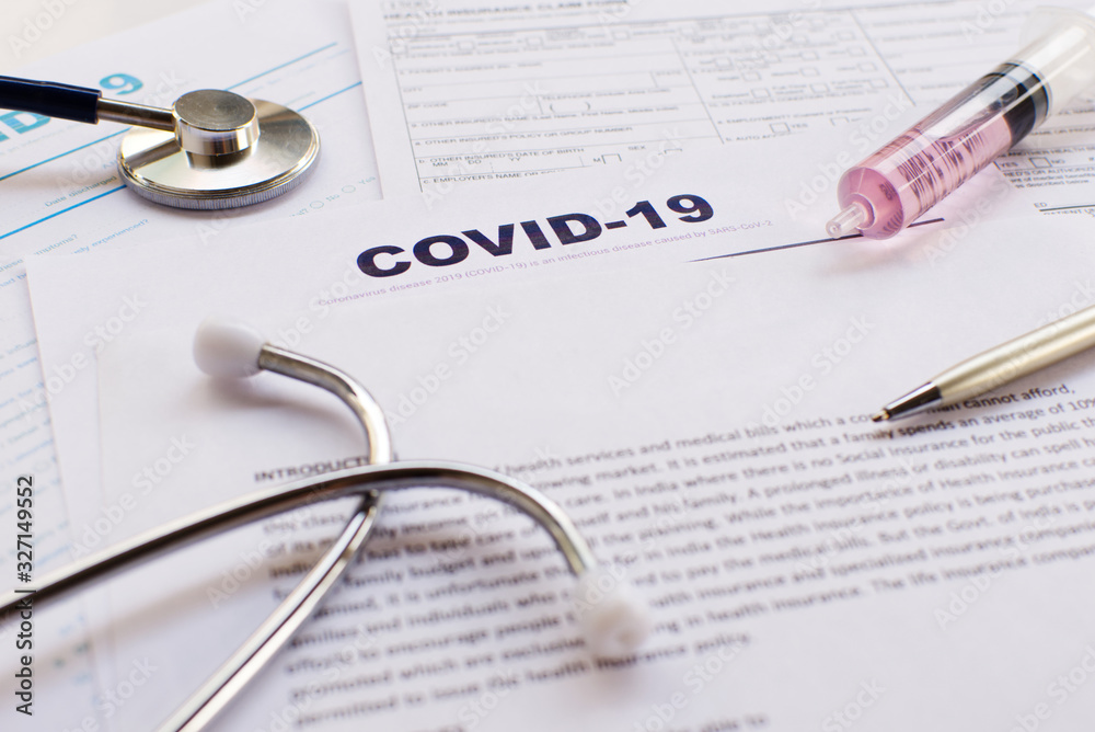 COVID-19 Health insurance concept. Syringe, pen and Stethoscope with copy space on application form Focus on COVID-19 Health insurance concept. Syringe, pen and Stethoscope with copy space on application form Focus on
