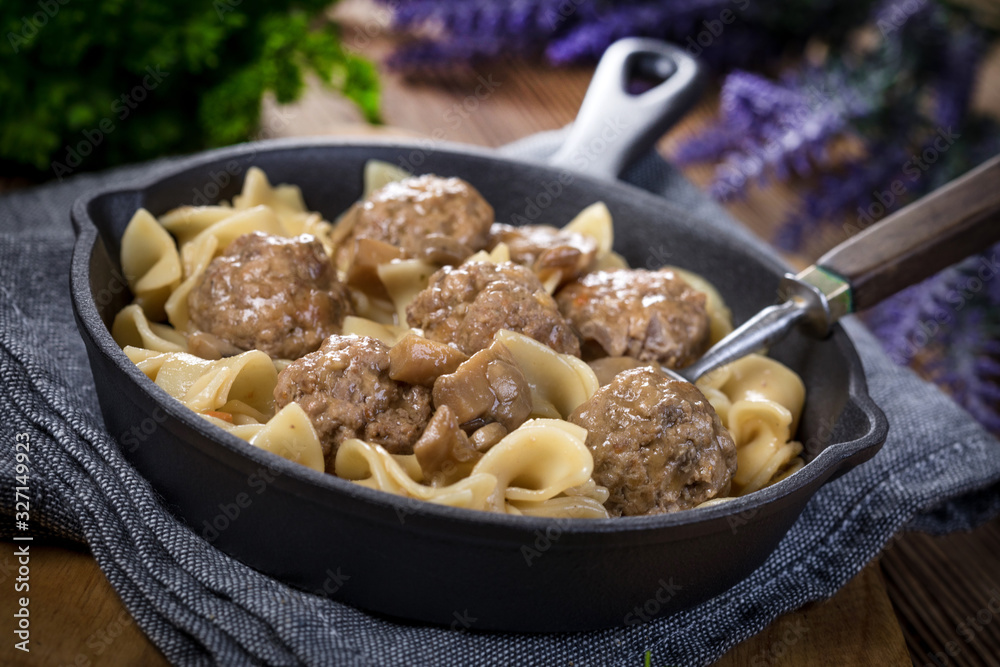 Pork meatballs with noodles in a cast iron skillet. Pork meatballs with noodles in a cast iron skillet.