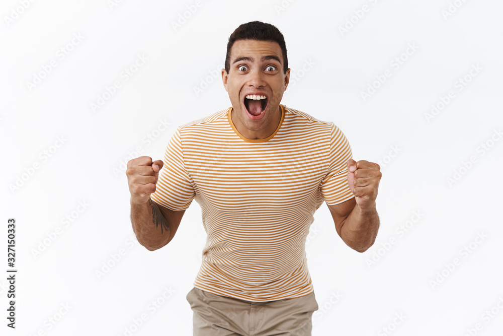 Pumped, excited handsome masculine guy winning big money, looking at score or sport match with happy, relieved expression, accomplish goal, fist pump from victory, achieve success Pumped, excited handsome masculine guy winning big money, looking at score or sport match with happy, relieved expression, accomplish goal, fist pump from victory, achieve success