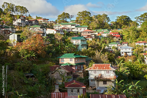 Scenic view on traditionally built houses with rusty metal roofs and metal sheets protecting the walls, seen in the town center of Sagada, Philippines photo