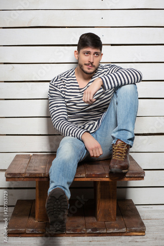 Handsome man sitting on a wooden table