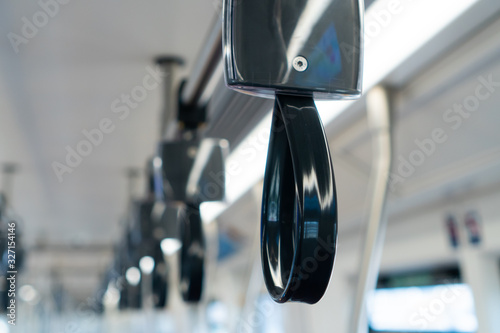 Close up of empty handrails in a metro subway train , Handle hand straps in public transportation for passenger safety.