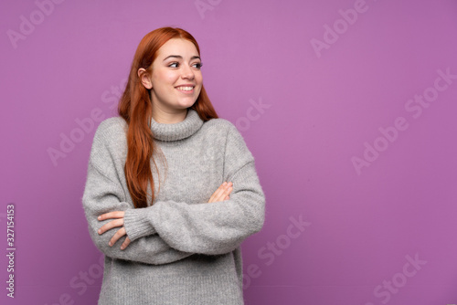 Redhead teenager girl over isolated purple background laughing © luismolinero