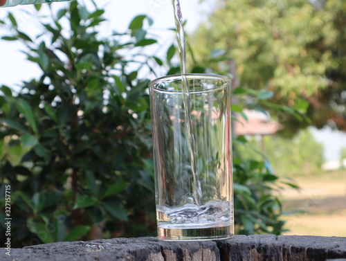 Filling water in glass with bubbles in summer.