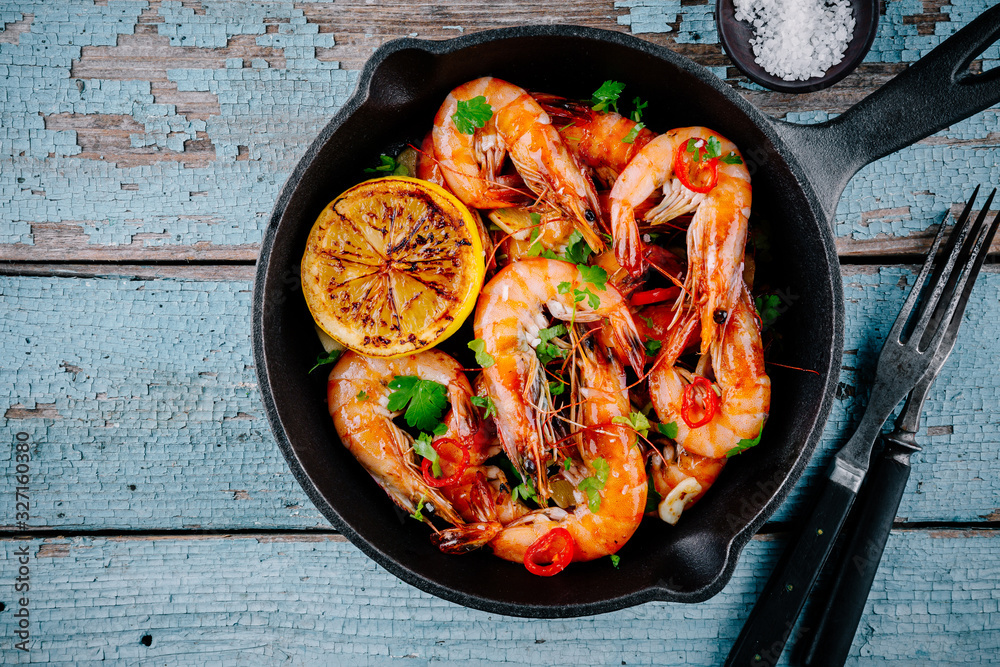 Roasted Prawns Shrimps in frying pan with lemon and chili pepper