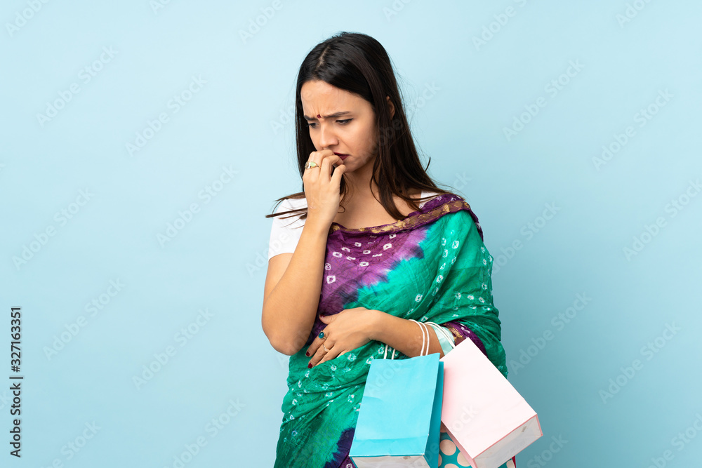 Young Indian woman with shopping bags having doubts Young Indian woman with shopping bags having doubts