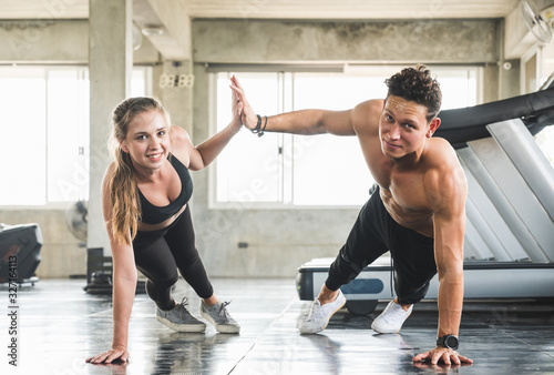Couple love young fitness man and women workout exercise together. Weight training and cardio program concept. © Nopphon