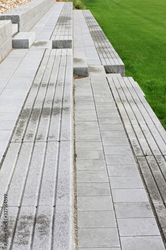Moderner Garten und Landschaftsbau: Terrassenförmige Gestaltung von Treppen und Gehwegen aus Beton Stein als Sitzplätze auf einem Sportplatz