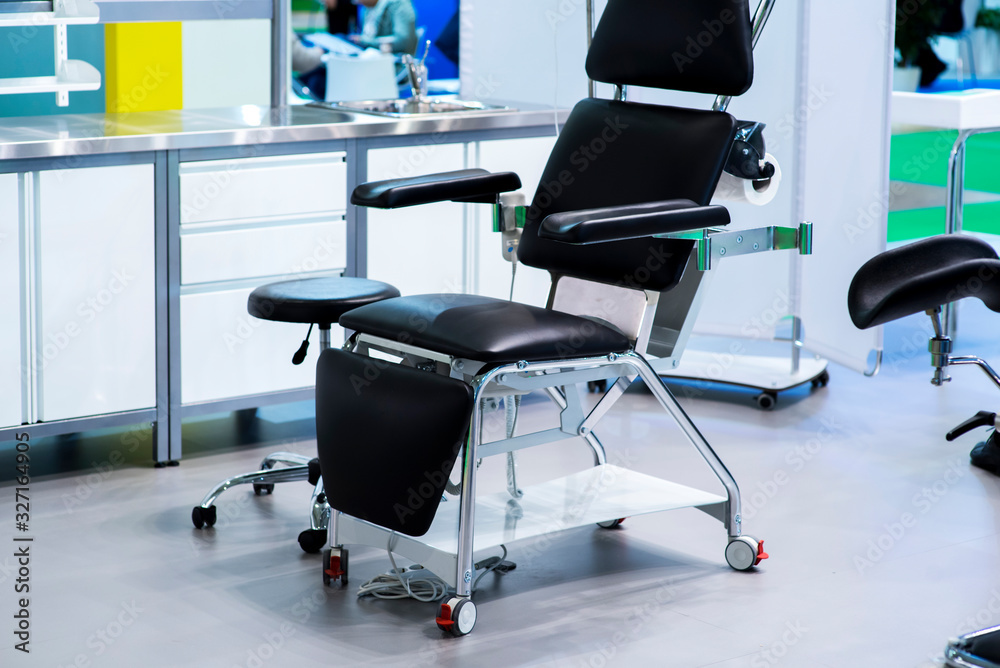 Blue gynecological chair in medical office in clinic. Modern interior in the gynecologist's office. Blue gynecological chair in medical office in clinic. Modern interior in the gynecologist's office.