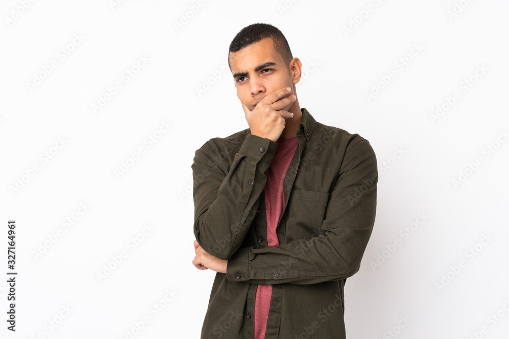 Young African American man over isolated white background having doubts and with confuse face expression Young African American man over isolated white background having doubts and with confuse face expression