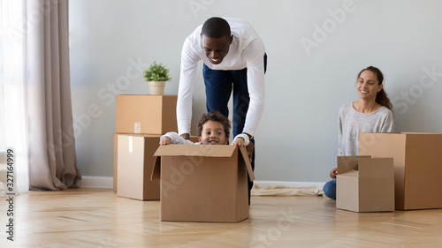 Happy African American family moving, having fun in new apartment