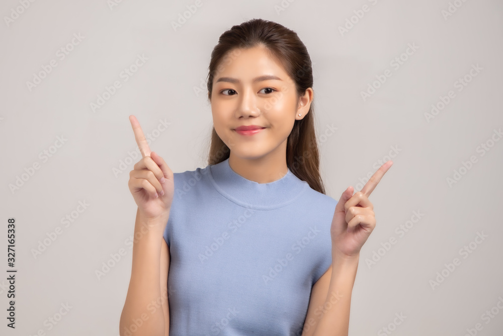 Thinking asian woman stand up isolated on white background.Asian female model smiling looking up.woman pointing fingers away on white background isolated. Thinking asian woman stand up isolated on white background.Asian female model smiling looking up.woman pointing fingers away on white background isolated.