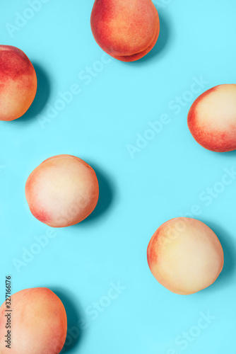 A few peaches on a turquoise background. Flat lay, top view.