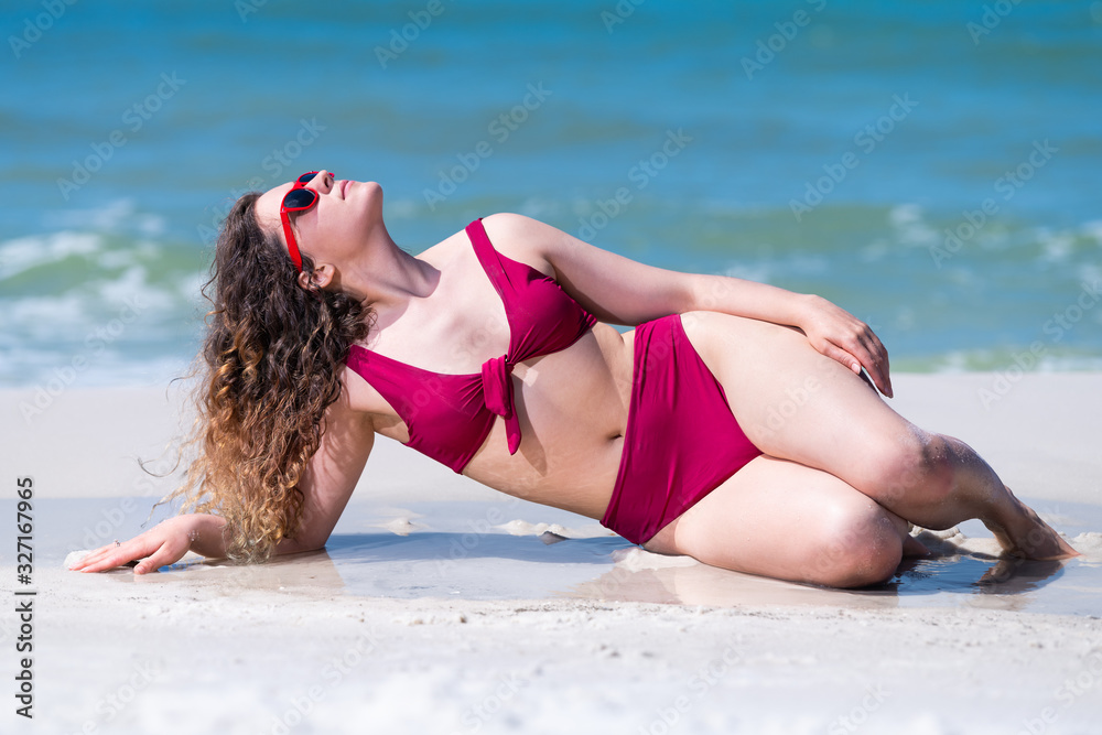 Young girl woman looking up in bikini bathing down posing by ocean sea green water in background in Santa Rosa Beach Stock-foto |