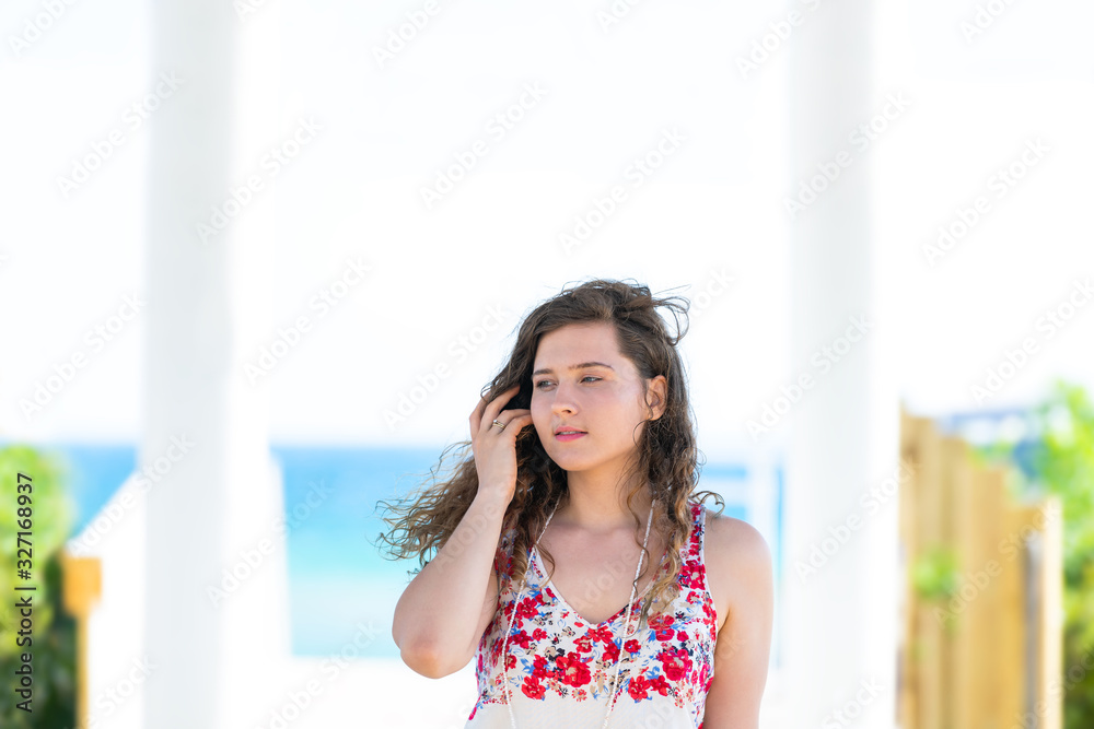 Seaside pavilion by gulf of mexico ocean with water and happy young woman girl touching hair in Florida architecture view during sunny day Seaside pavilion by gulf of mexico ocean with water and happy young woman girl touching hair in Florida architecture view during sunny day