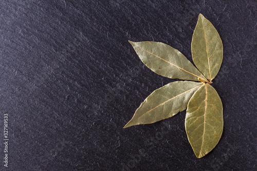 Fotografia, Obraz ground dried bay leaf on a dark stone background