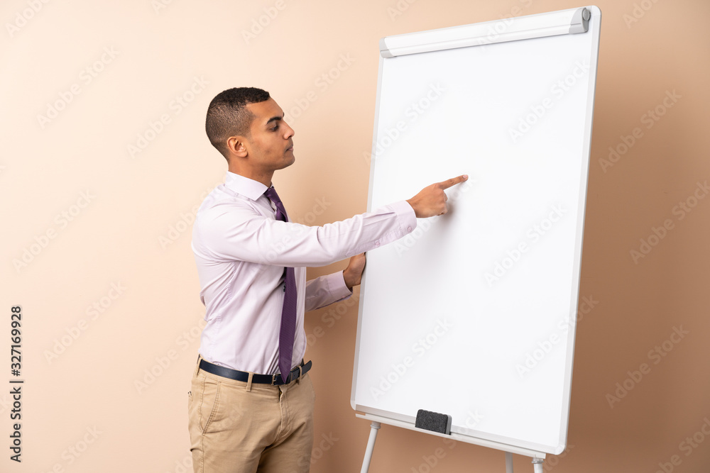 Young business man over isolated background giving a presentation on white board Young business man over isolated background giving a presentation on white board