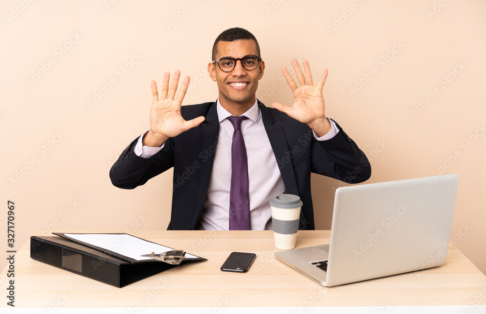 Young business man in his office with a laptop and other documents counting ten with fingers Young business man in his office with a laptop and other documents counting ten with fingers