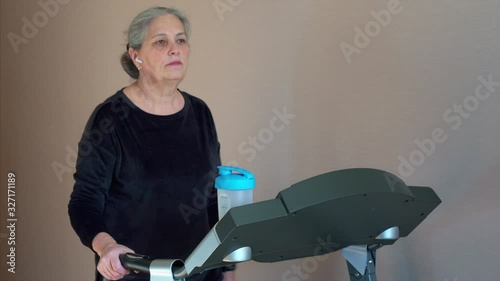 Caucasian senior woman is drinking a protein shake drink. Fitness at home concept.
