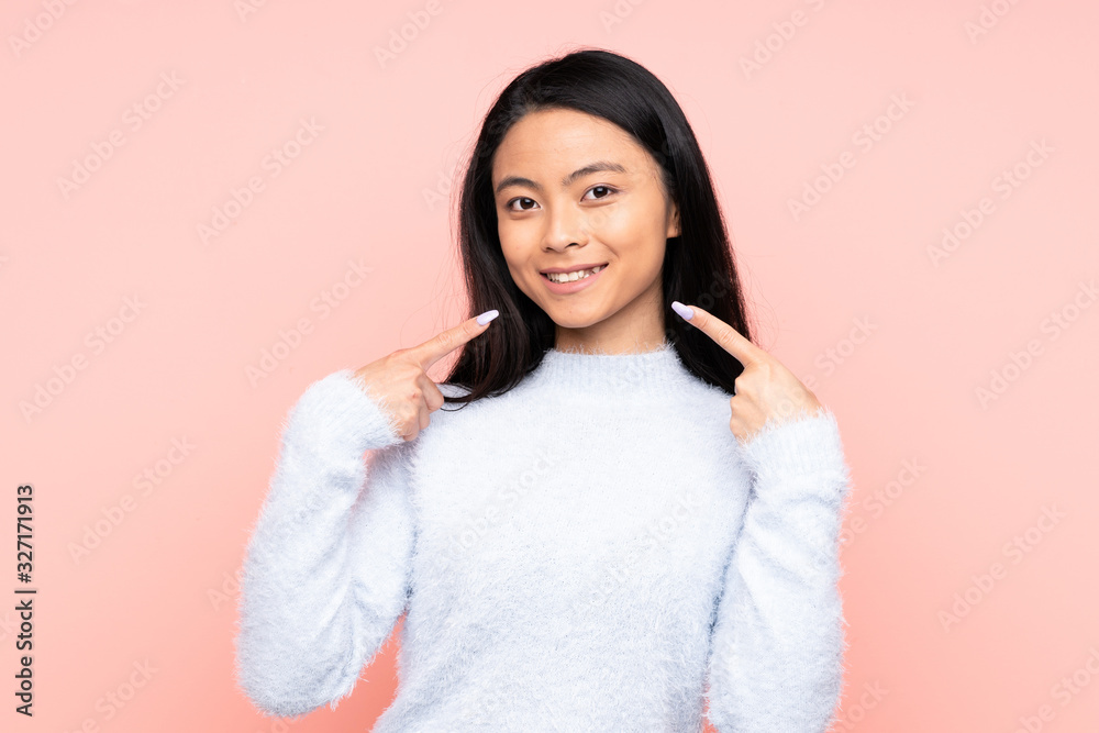 Teenager Chinese woman isolated on pink background giving a thumbs up gesture Teenager Chinese woman isolated on pink background giving a thumbs up gesture