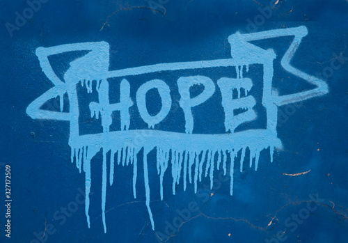 Grafitti street art słowo hope namalowane sprayem na niebieskiej ścianie