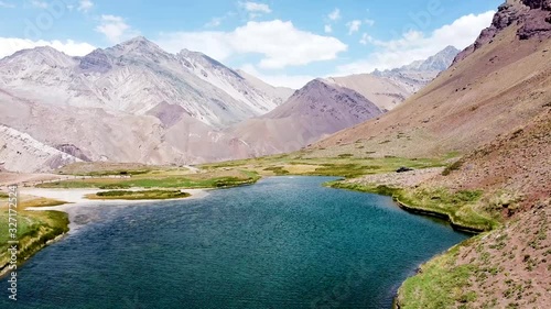 Fly over Laguna De Horcones lake in the mountains on the trail to Aconcagua Mountain - highest peak in Andes. Aerial view of mountain lake in valley in Andes mountains. Mendoza province, Argentina photo