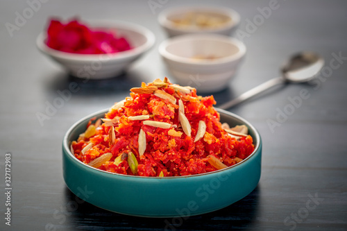 Gajar ka halwa is a sweet dessert pudding from India made from carrot, served in a bowl. Garnished with cashew, almond and pistachio nuts.