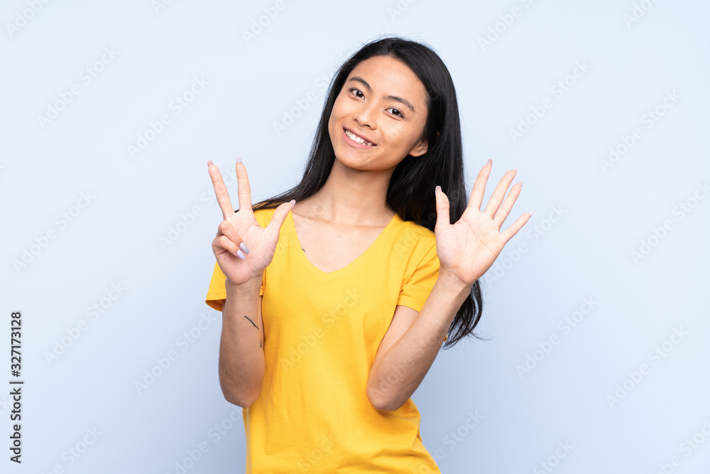 Teenager Chinese woman isolated on blue background counting eight with fingers Teenager Chinese woman isolated on blue background counting eight with fingers