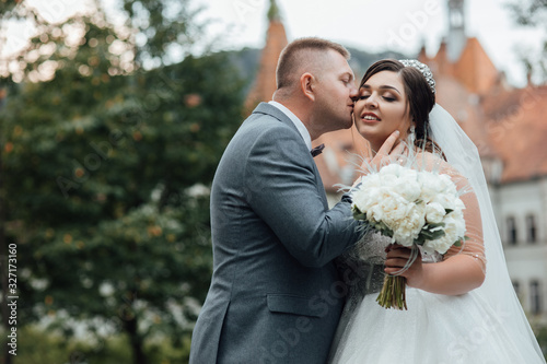 Beautiful summer wedding that took place in the old city with wonderful architecture. The best day of a young couple. Sensual and tender bride and groom outdoors. 