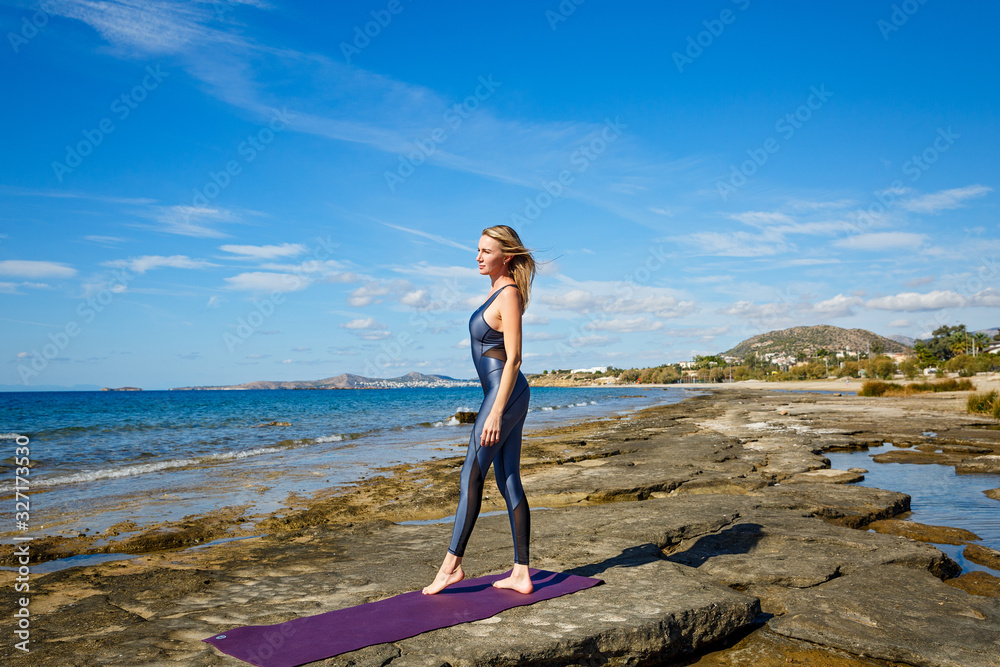 Woman does sports exercises on the beach