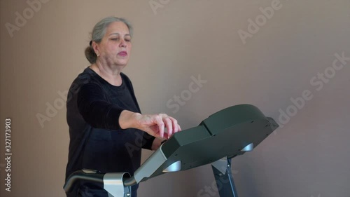 Sports Woman Wearing Wireless Headphones, Listens to a Music while Running on a Treadmill. 