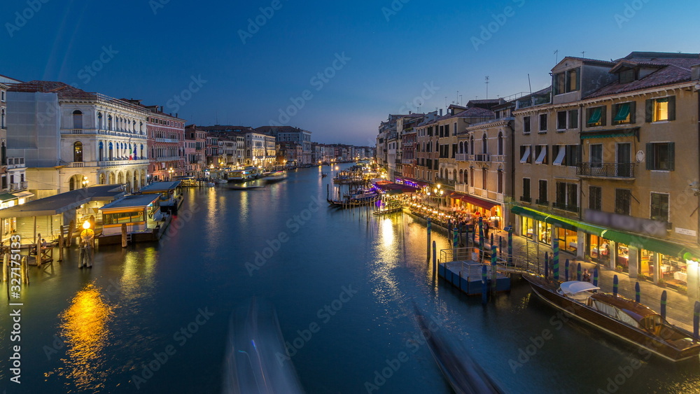 Grand Canal in Venice, Italy day to night timelapse. View on gondolas and city lights from Rialto Bridge.