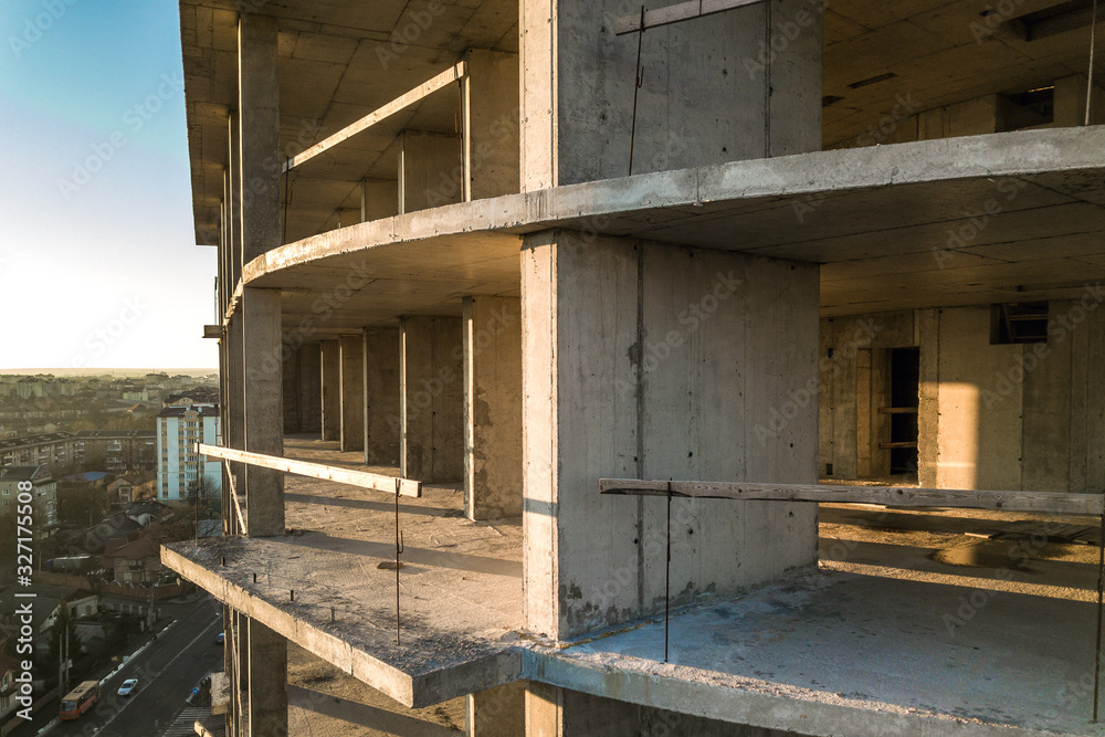 Obraz premium Aerial view of concrete frame of tall apartment building under construction in a city.