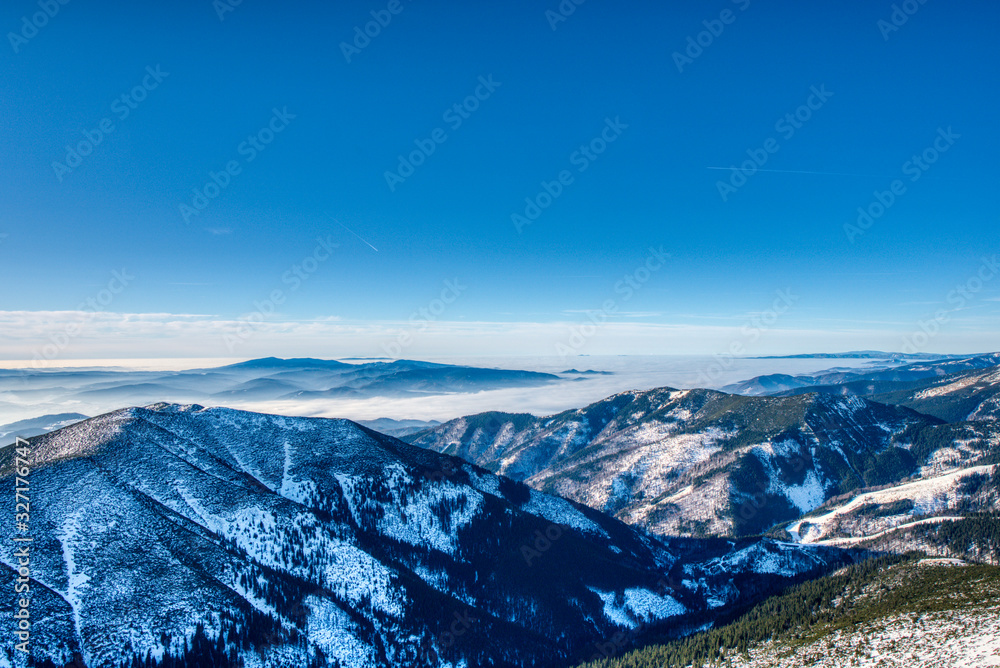 beautiful view of valley and mountains covered by mist in low Tatra mountains from dumbier, Slovakia Dumbier