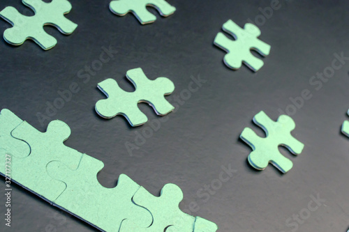 Green puzzles on a black background close-up