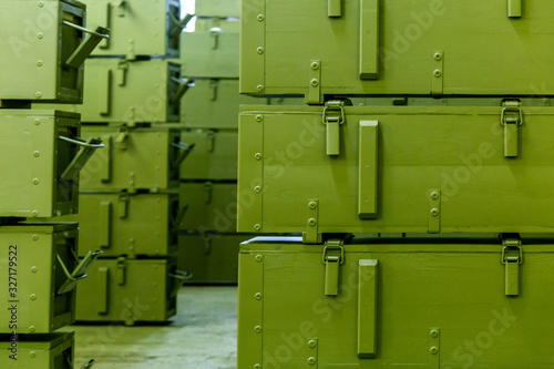 stacks of abstract green military crates without any markings - close-up with selective focus and background blur photo